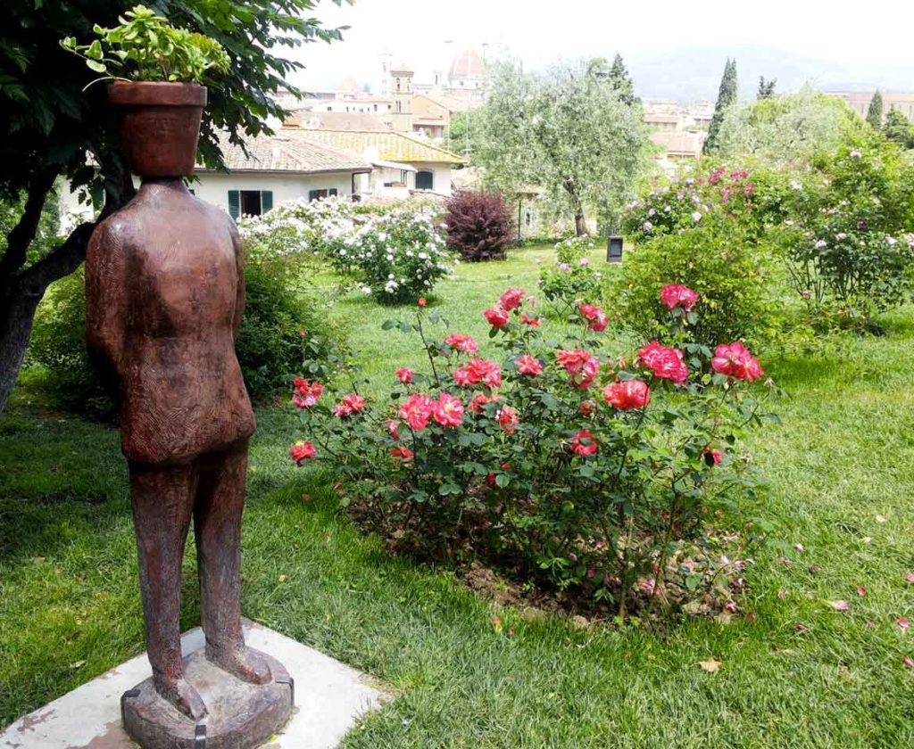 pot-head sculpture by Jean Michel Folon and a rose bush