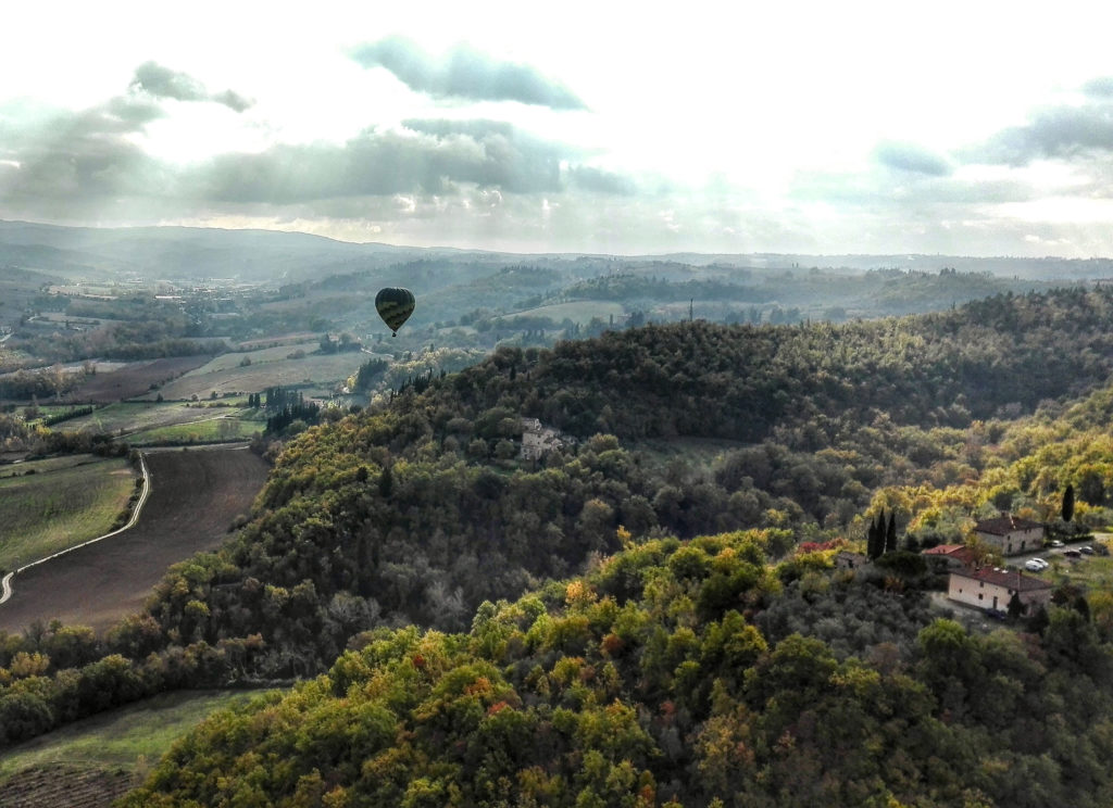 view of the chianti rolling hills with dramatic light and a hot air ballon