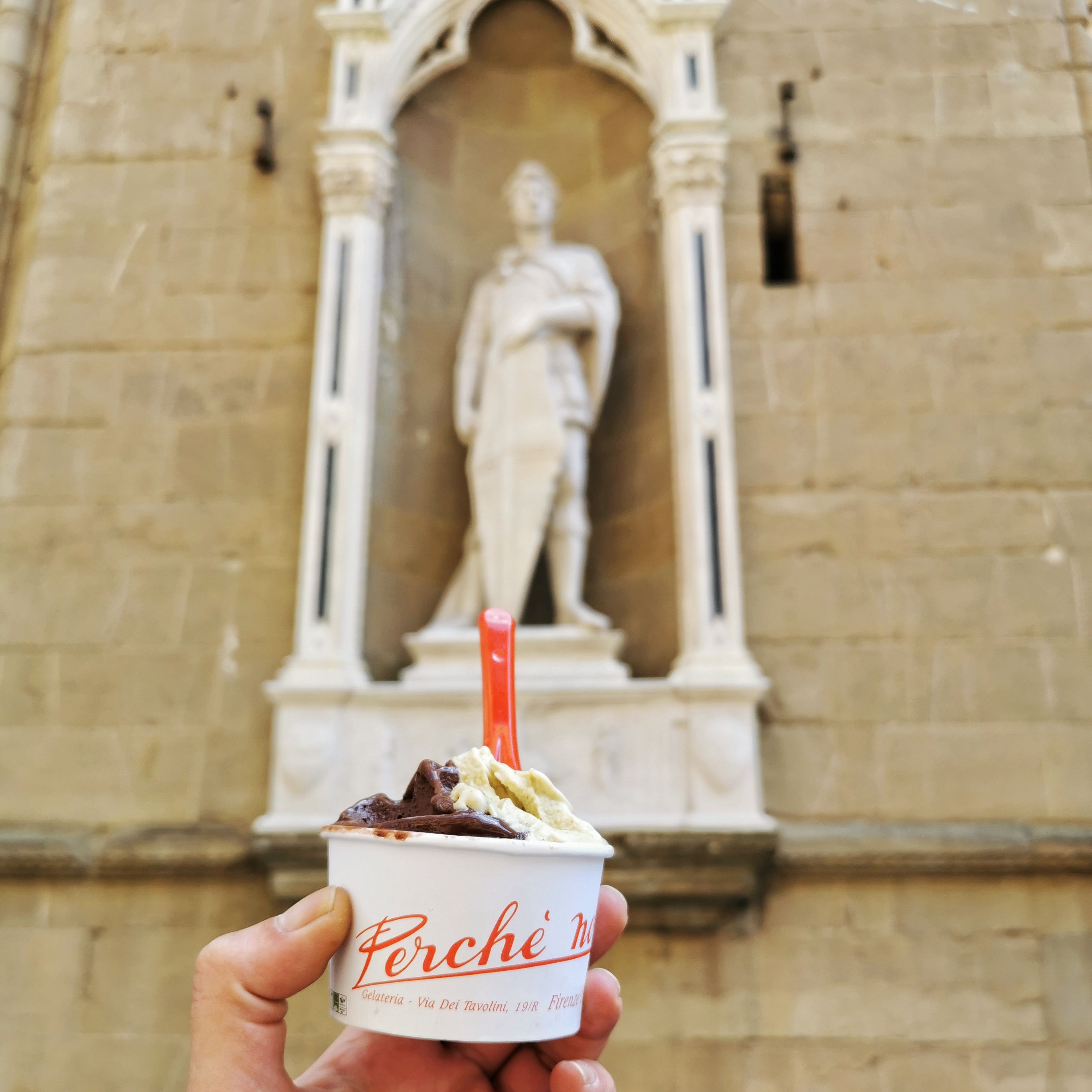 cup of iitalian ice cream in front of the statue of saint George by Donatello