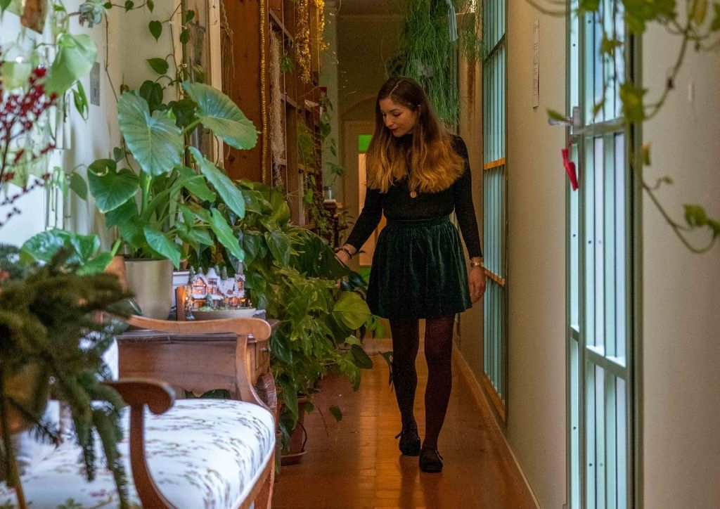 lucrezia taking care of plants in the corridor