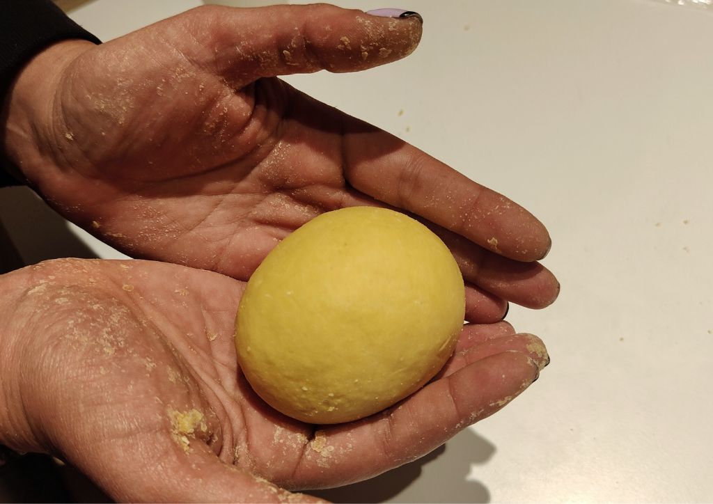hands with a ball of pasta dough at a cooking school in Florence