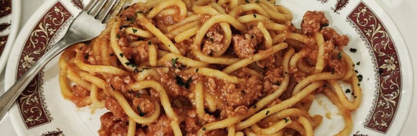 a dish of pici with ragù in a restaurant in Tuscany