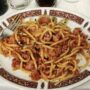 a dish of pici with ragù in a restaurant in Tuscany