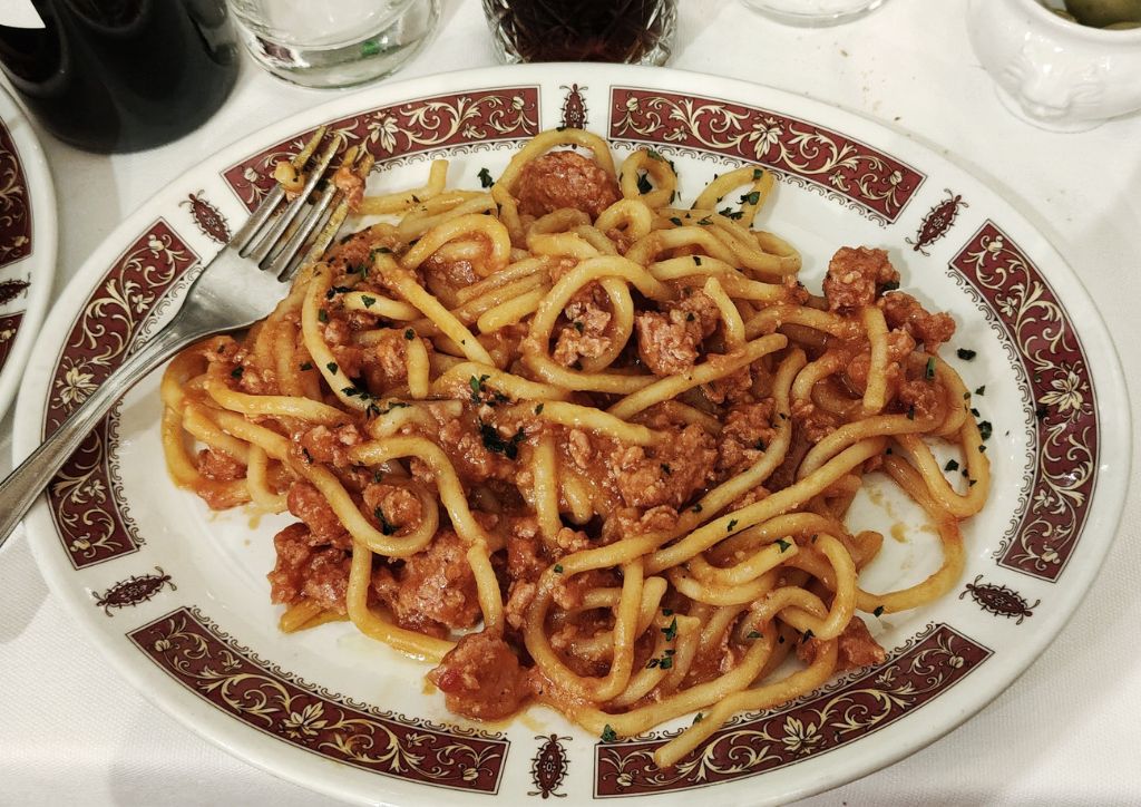 a dish of pici with ragù in a restaurant in Tuscany